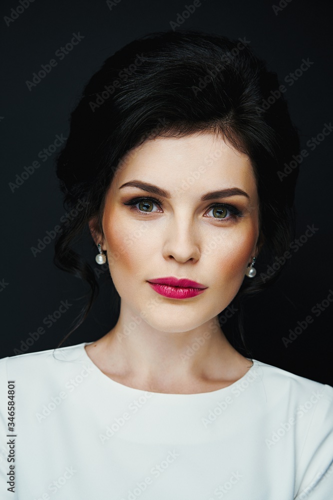 Portrait of gorgeous brunette woman against studio background . Sensual young woman with red lips and bright makeup. Beautiful healthy face of the young pretty woman with fresh skin.