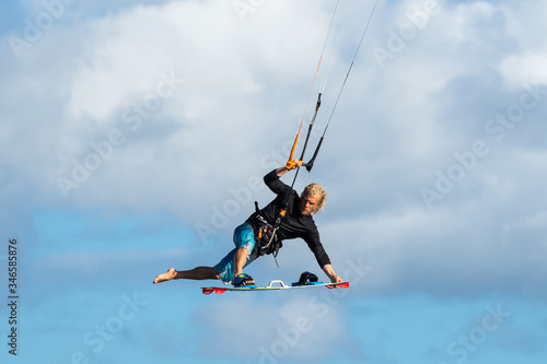 professional kiter makes the difficult trick on a beautiful background of spray and beautiful clouds of Mauritius