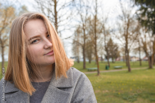 Close-up portrait of a girl in the park. Place for text.