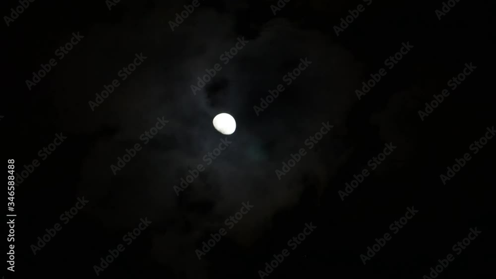 Moon on dark sky while clouds passing