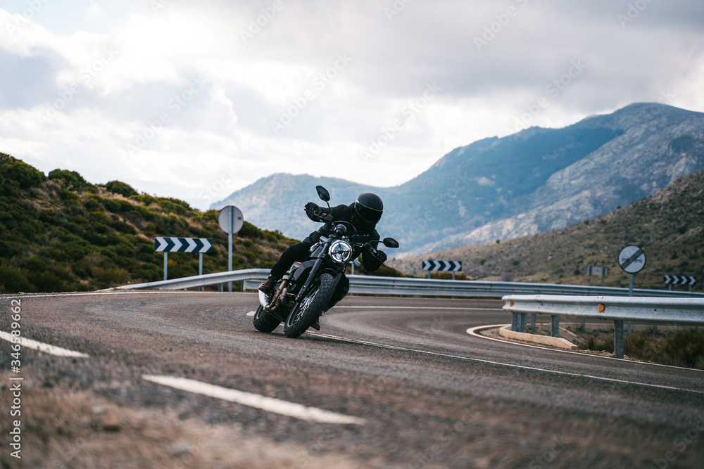 Biker riding a motorcycle on roadway in the mountains