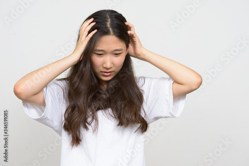 Portrait of stressed young Asian woman having headache