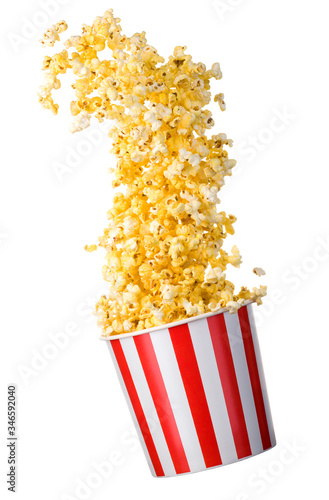 Flying popcorn from paper striped bucket isolated on black background