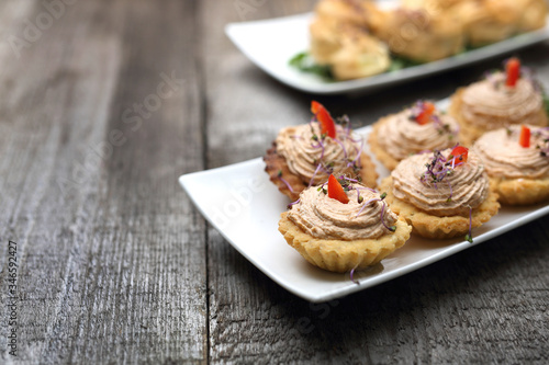 Shortbread muffins stuffed with tuna paste. A dry starter. Appetizing dish on a wooden table.