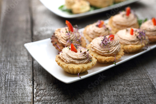 Shortbread muffins stuffed with tuna paste. Appetizing dish on a wooden table.