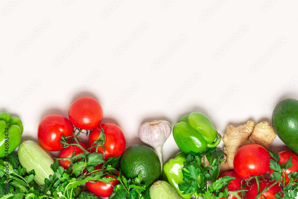 Fresh green and red vegetables on a light background, top view, free space for text. Tomatoes, peppers, avocados, zucchini and parsley flat lay, copy space. Healthy vegetarian food concept. Fresh green and red vegetables on a light background, top view, free space for text. Tomatoes, peppers, avocados, zucchini and parsley flat lay, copy space. Healthy vegetarian food concept.
