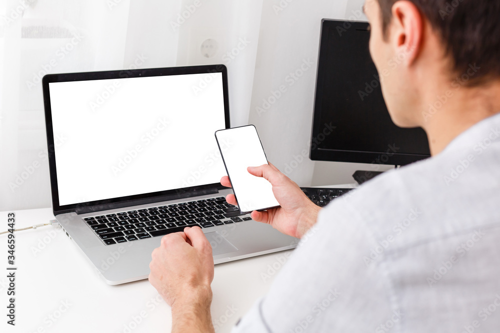 Back view of male person sitting front open laptop computer with blank empty screen for your information or content, modern businessman working in internet Back view of male person sitting front open laptop computer with blank empty screen for your information or content, modern businessman working in internet