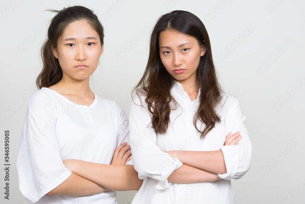 Two stressed young Asian women as friends with arms crossed together Two stressed young Asian women as friends with arms crossed together