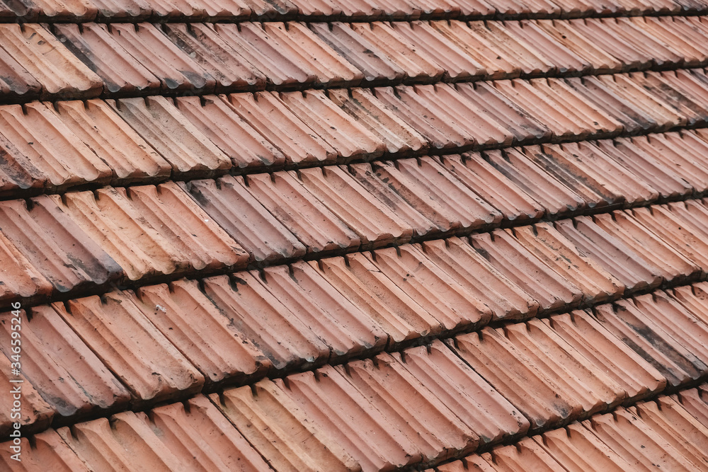Old roof tiles on the roof of an house as a background image. Place for text or advertising Old roof tiles on the roof of an house as a background image. Place for text or advertising