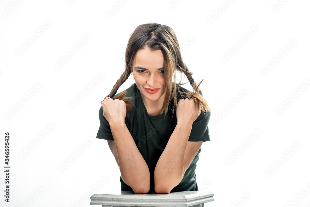 Young beautiful woman portrait with long brown hair over white studio background. Curling hair on fingers. Positive emotions concept. Closeup Young beautiful woman portrait with long brown hair over white studio background. Curling hair on fingers. Positive emotions concept. Closeup