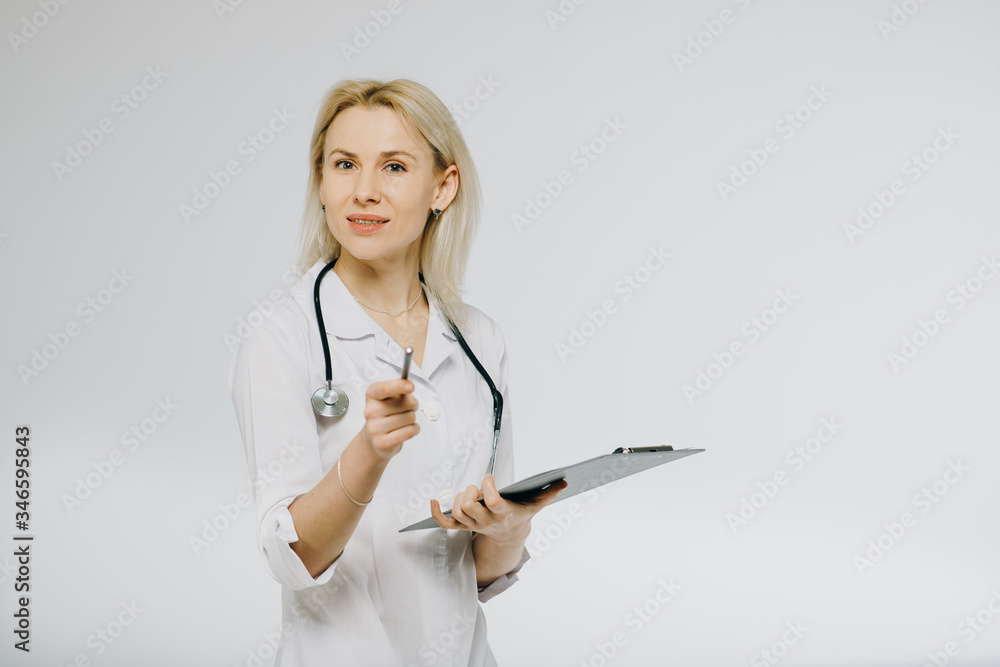 Confident female doctor in white medical coat and stethoscope looking calm on clipboard with patient s medical history. Confident female doctor in white medical coat and stethoscope looking calm on clipboard with patient s medical history.