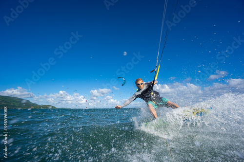 professional kiter makes the difficult trick on a beautiful background of spray and beautiful clouds of Mauritius