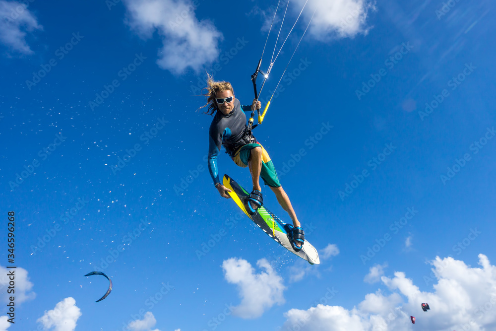 professional kiter makes the difficult trick on a beautiful background of spray and beautiful clouds of Mauritius professional kiter makes the difficult trick on a beautiful background of spray and beautiful clouds of Mauritius