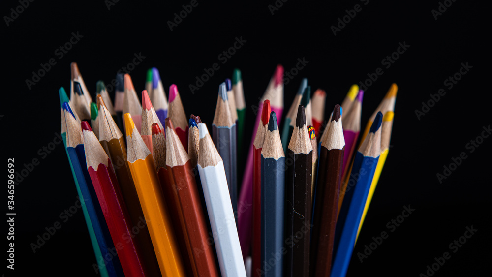 Fototapeta premium colored pencils on a black background with copy space