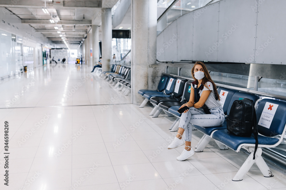Girl sitting in an empty airport in a mask during a pandemic in Thailand Girl sitting in an empty airport in a mask during a pandemic in Thailand