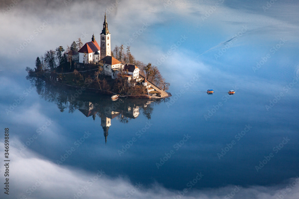 amazing panorama of Lake Bled Blejsko Jezero on a foggy morning with the Pilgrimage Church of the Assumption of Maria on a small island and Bled Castle and Julian Alps in backgroud amazing panorama of Lake Bled Blejsko Jezero on a foggy morning with the Pilgrimage Church of the Assumption of Maria on a small island and Bled Castle and Julian Alps in backgroud