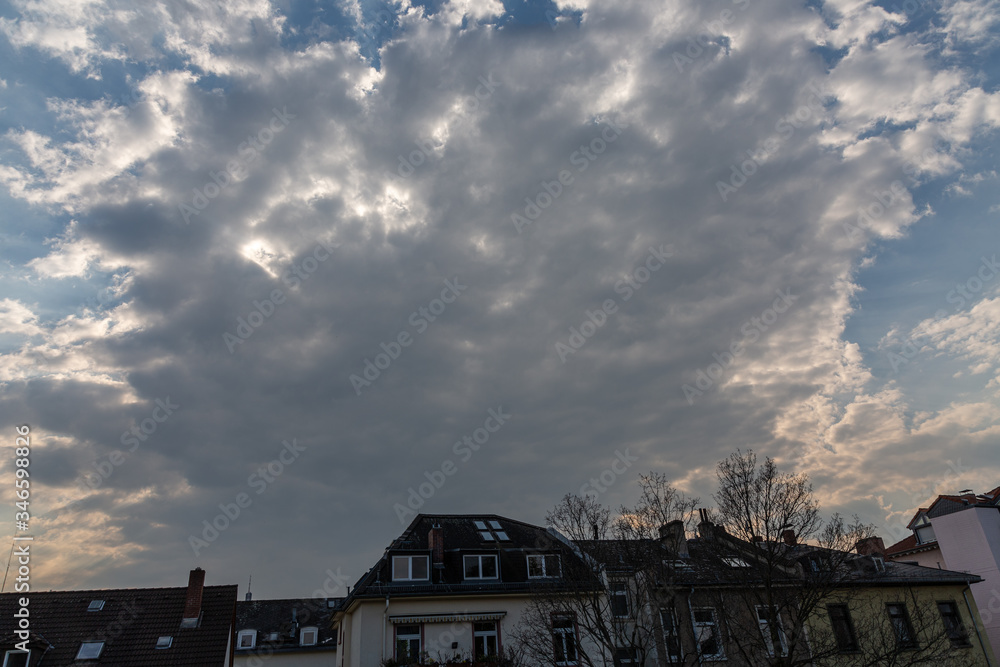 Sunset with cloudy dramatic sky and house roofs Sunset with cloudy dramatic sky and house roofs