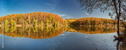 Beautiful autumn landscape with reflection in the water at the hydropark