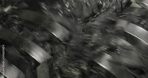 Closeup view of working shredder mashine shreddering rubber car tires on processing plant. Environmental protection, recycling of used materials. Recycled automobile tyres on factory.