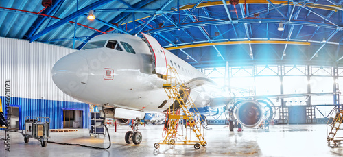 Panoramic view of aerospace hangar, civil aviation aircraft, repair and maintenance of mechanical parts in an industrial workshop.