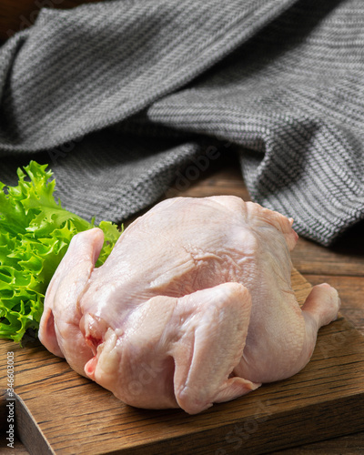 Photos Chicken on a wooden Board on a brown wooden table