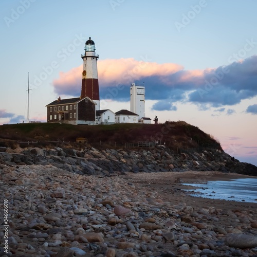 Montauk point lighthouse at sunset with pink sky shot from ocean side
