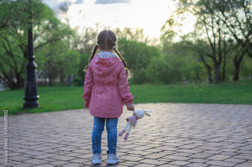 little girl outdoors alone with a toy, without parents, social