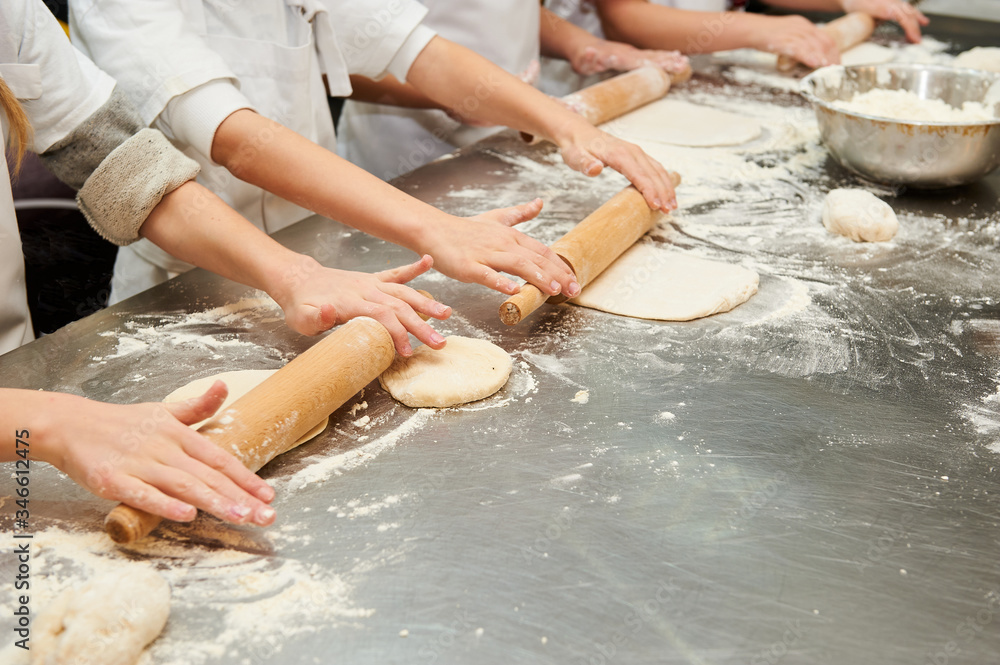 Little kids make dough products. Flour is scattered around. Hands close up. Little kids make dough products. Flour is scattered around. Hands close up.