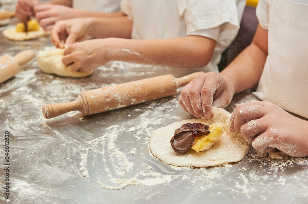 young children fill a flour product with a sweet filling. Master class baking young children fill a flour product with a sweet filling. Master class baking