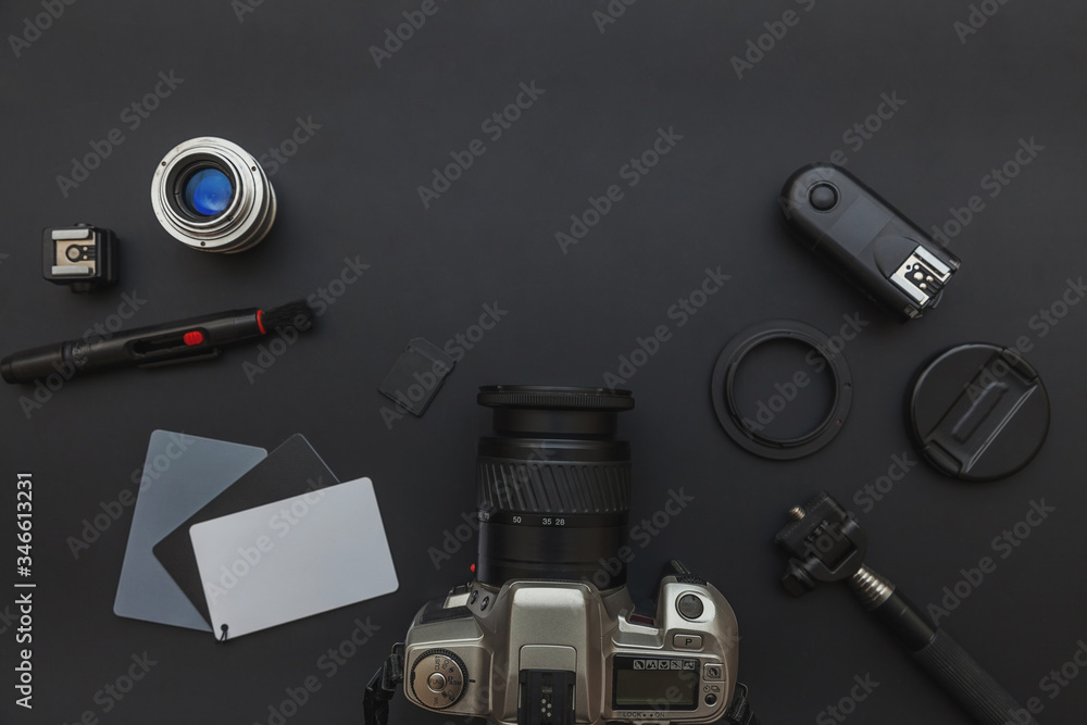 Photographer workplace with dslr camera system, camera cleaning kit, lens and camera accessory on dark black table background. Hobby travel photography concept. Flat lay top view copy space