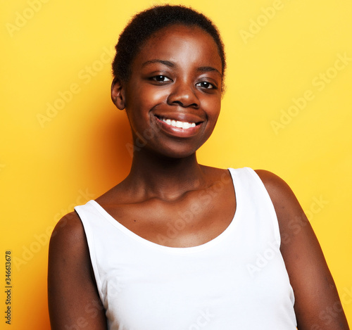 Beautiful happy young african woman isolated over yellow background