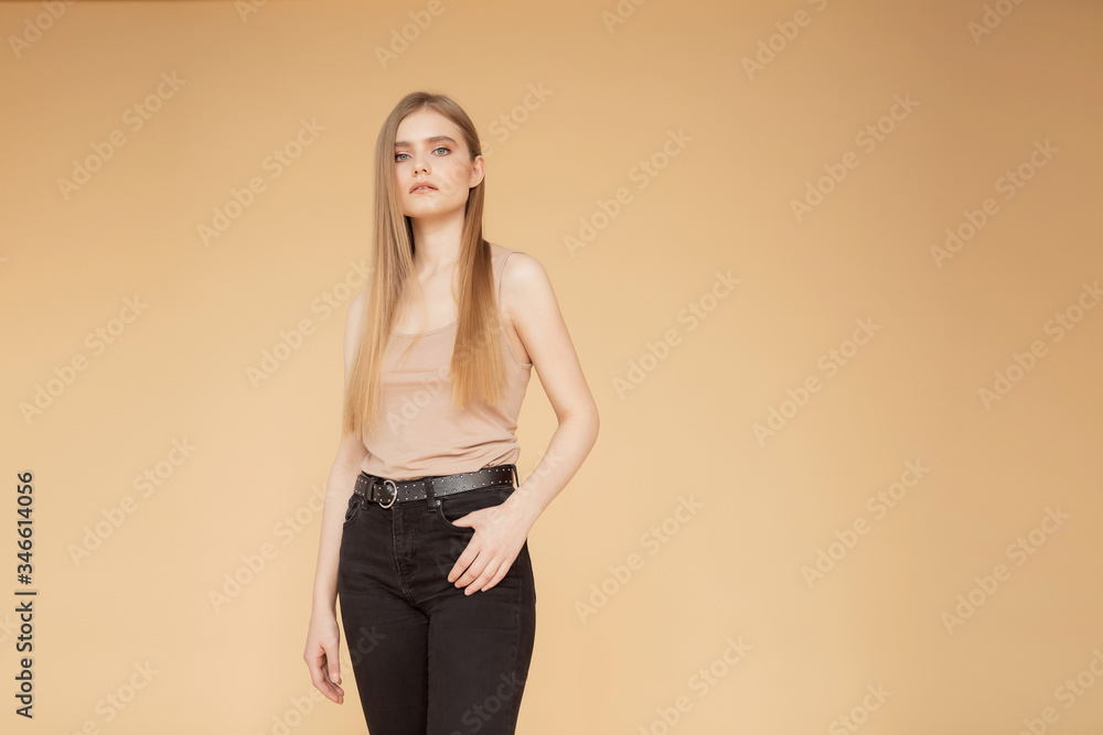 Beauty care fashion concept. Portrait young woman with blonde hair isolated over beige background Beauty care fashion concept. Portrait young woman with blonde hair isolated over beige background