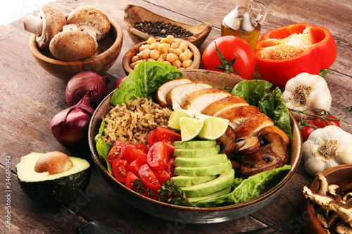 Healthy salad bowl with quinoa, tomatoes, chicken, avocado, lime and mixed greens and mushrooms