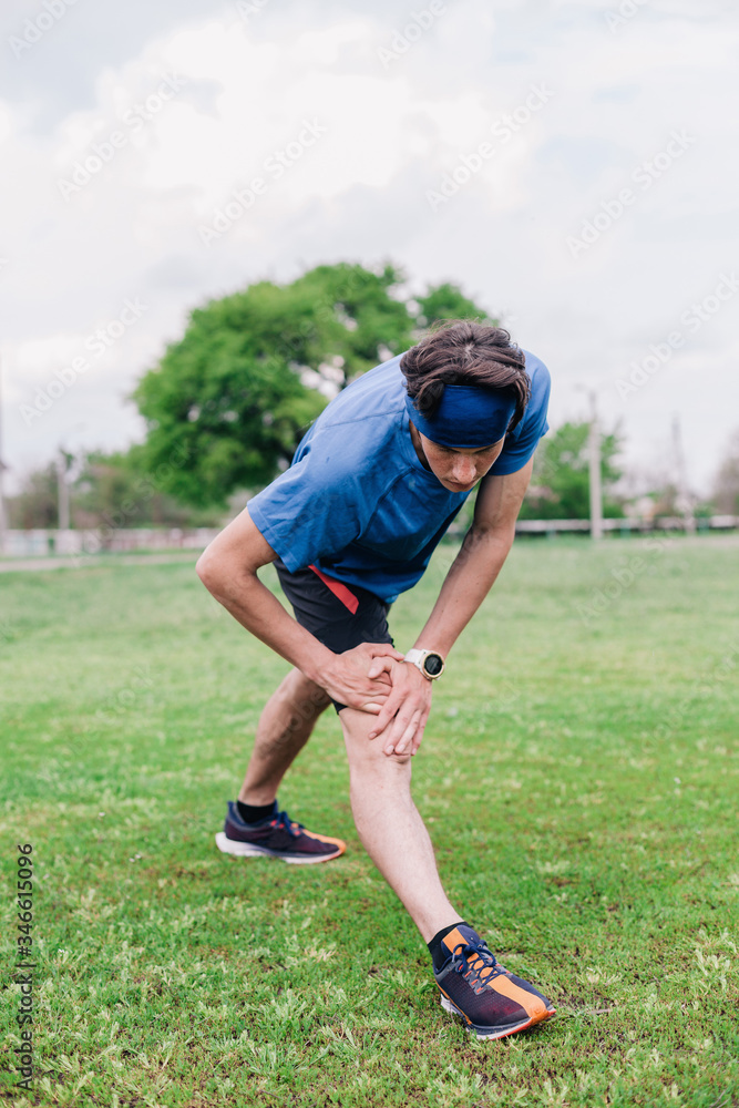 young guy does warm-up at the stadium before running young guy does warm-up at the stadium before running