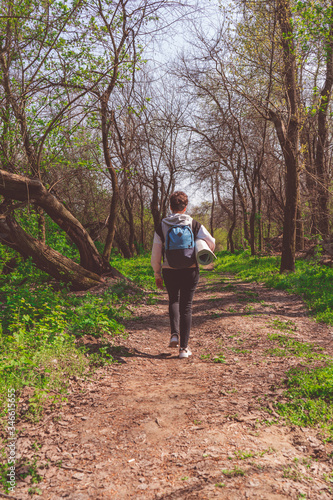 Solo traveller - woman hiker walking in spring forest