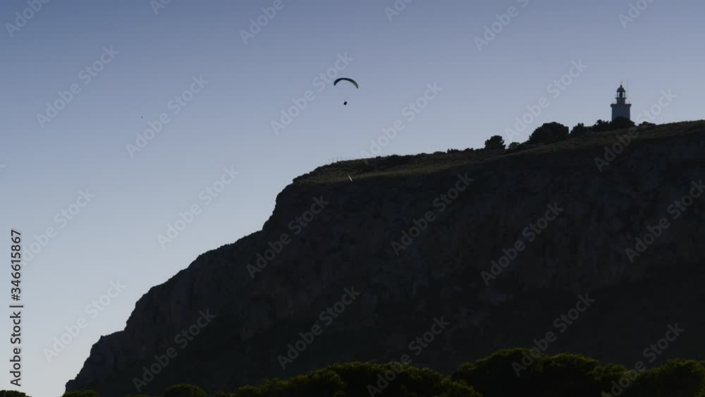 Paragliding. Extreme sport. Paraglider silhouette flying in the sky. Spain Alicante Santa Pola region Paragliding. Extreme sport. Paraglider silhouette flying in the sky. Spain Alicante Santa Pola region