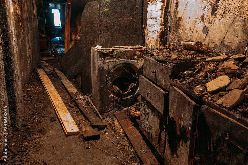 Burnt house interior. Burned burnt bathroom, Fused remains of furniture and washing machine