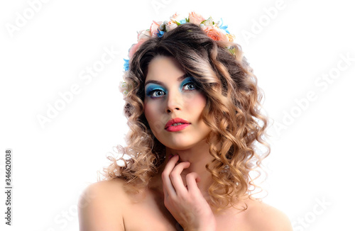 Beauty portrait of a young cute model with bright makeup and flowers in her hair