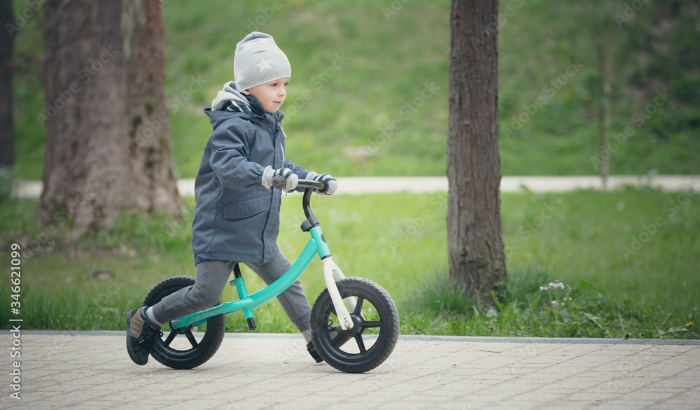 Little boy rides his first bike and enjoys - Learning to ride a bike - Active way of spending time - Cool spring day. Little boy rides his first bike and enjoys - Learning to ride a bike - Active way of spending time - Cool spring day.