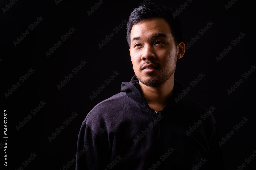 Face of young Asian man with hoodie thinking