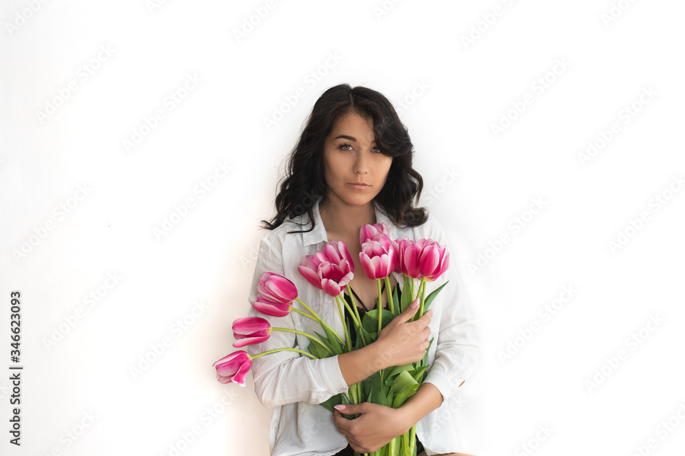A portrait of beautiful young woman with pink tulips. A portrait of beautiful young woman with pink tulips.