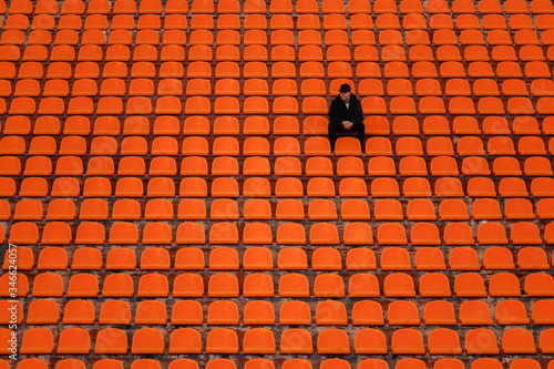 lonely man on the empty stadium seat cheering for the team,the concept of loneliness.