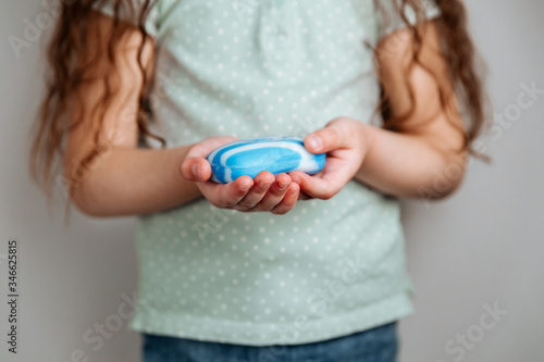 A girl holding soap in her hands.