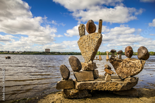 Set of balanced stone sculptures by the namesake artist, perched on the edge of the Ottawa River.