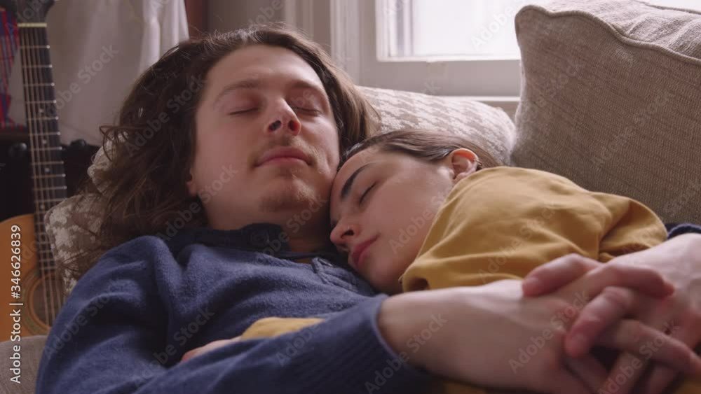 Couple snuggle up on couch to take a nap. Couple snuggle up on couch to take a nap.