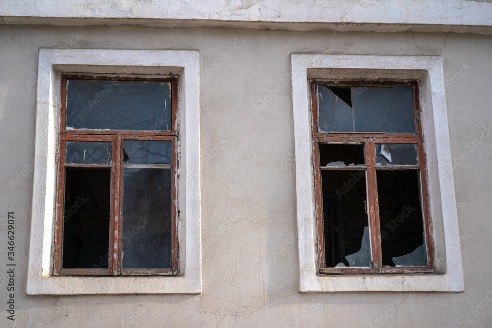 Broken glass in the windows of an old house