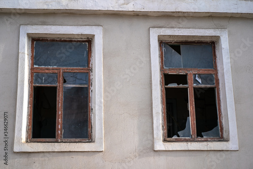 Broken glass in the windows of an old house