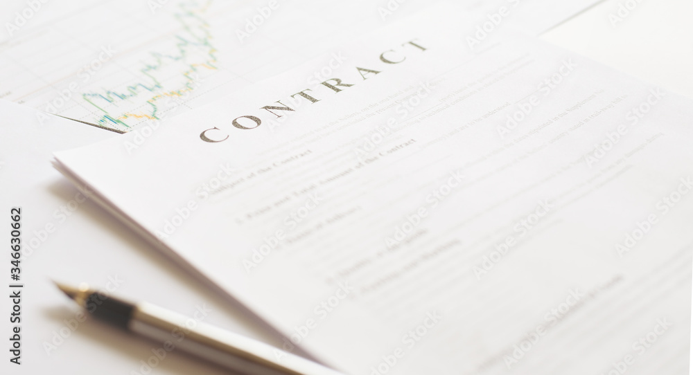 Contract paper and pen on white desk background. Focus on title Contract. Defocused pencil. Contract paper and pen on white desk background. Focus on title Contract. Defocused pencil.
