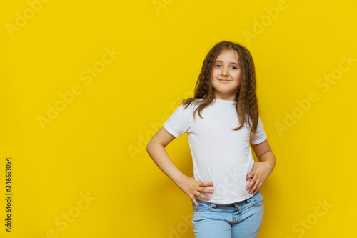 Beautiful little fashion model on Yellow studio background.