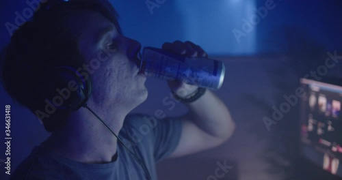 Man drinking energy drink playing video games